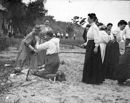 Beach event-- Group of women with knealing man